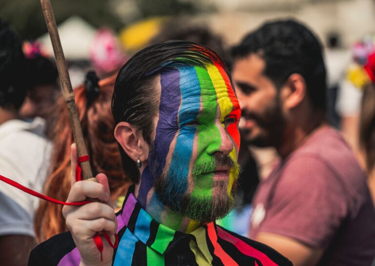 Shamed in the 3D, Right in the 5D Colorful face paint at a lively LGBT pride parade in Milan, showcasing individuality and celebration.